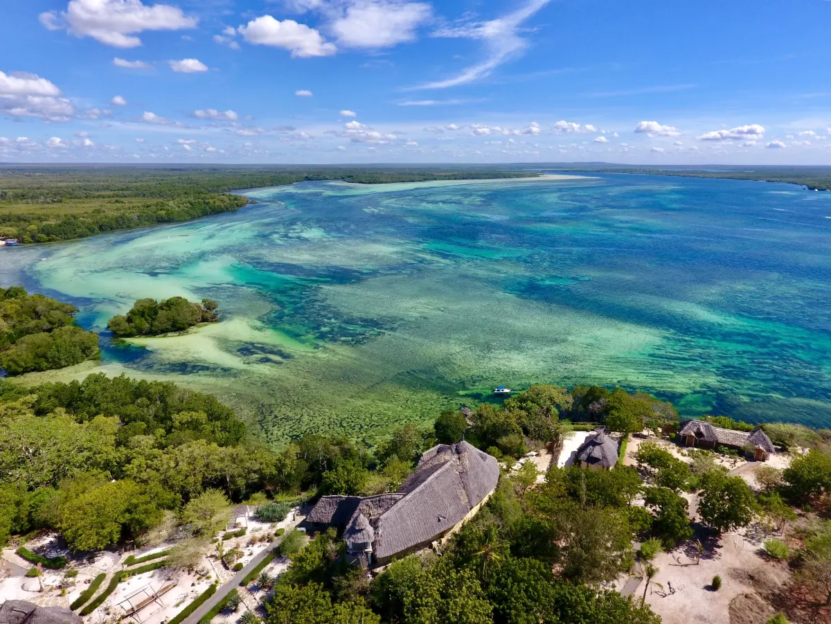 Aerial view of the thatched lodges on their headland where Mida Creek meets the Indian Ocean
